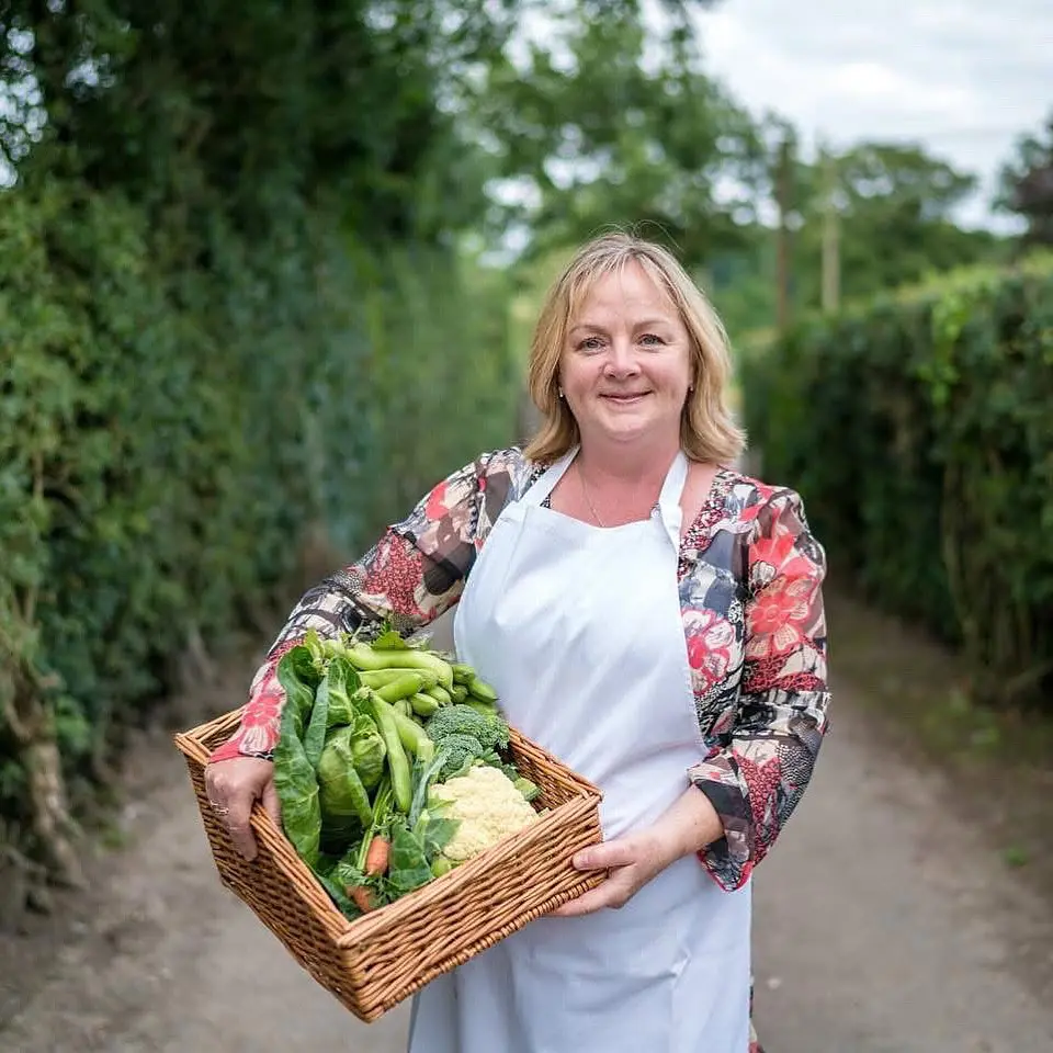 Kim Clark holding fresh home grown produce in a basket
